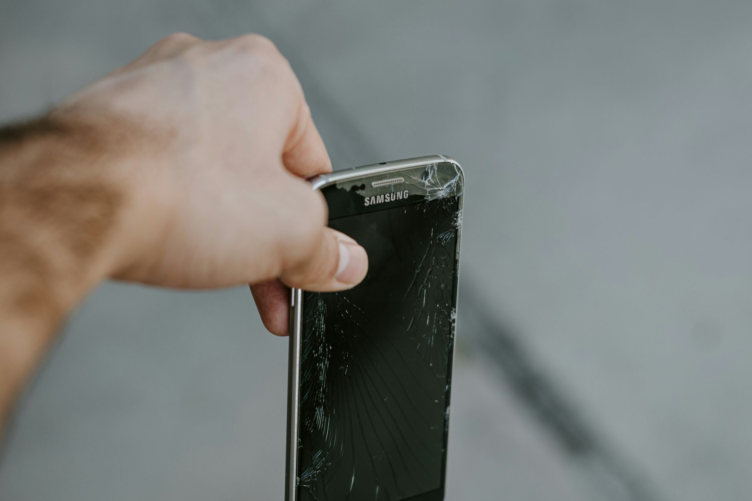shattered smartphone screen on pavement - Samsung Galaxy S6 with shattered screen