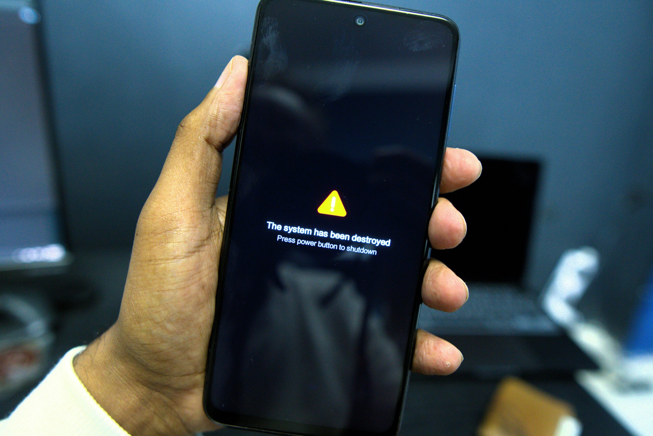 Smartphone with security warning screen - Phone shows a system failure warning message.