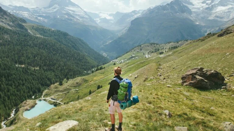 Hiker checking phone for signal in remote mountains - Guided Tour de Monte Rosa Hiking Adventure | 57hours