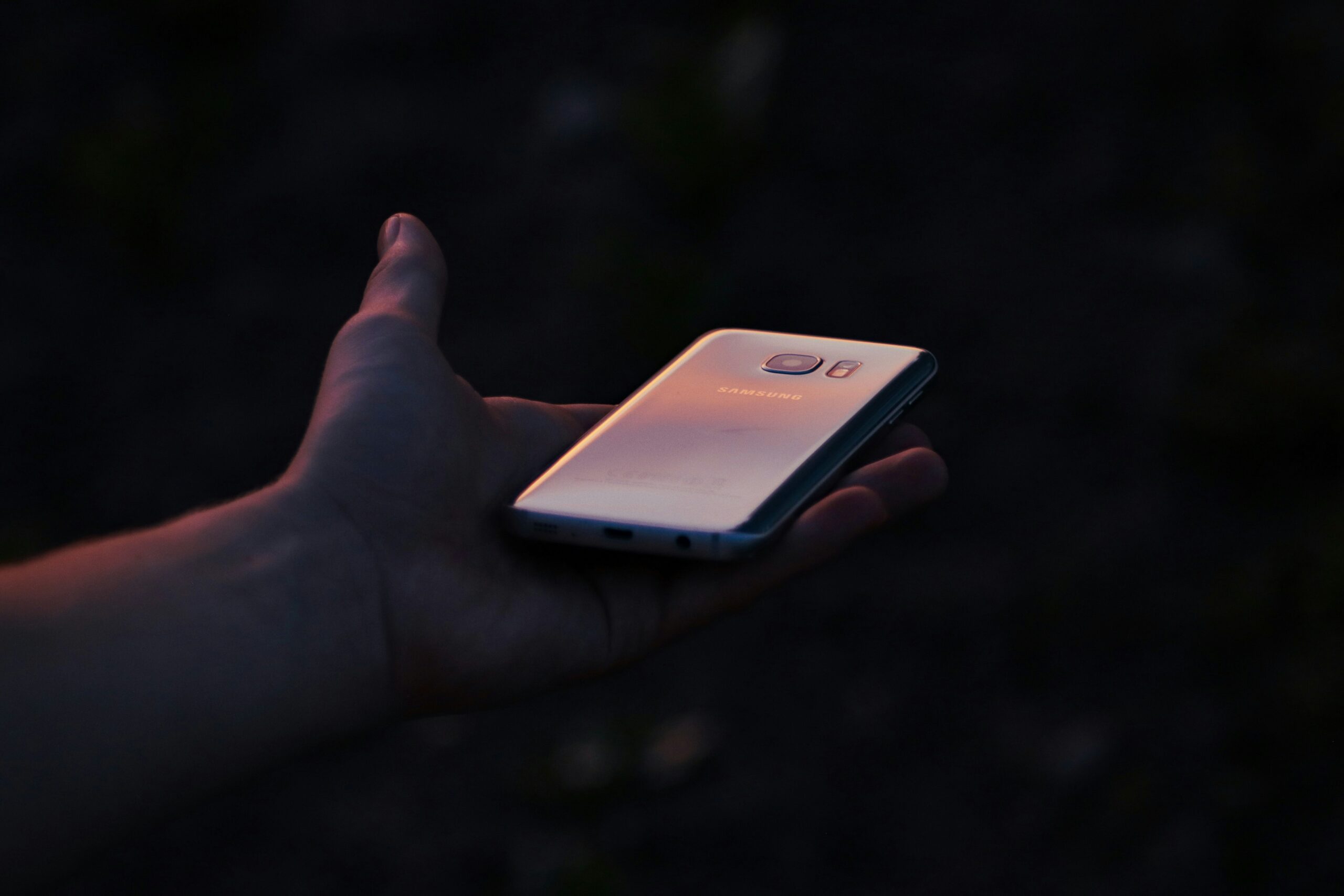 hand holding smartphone with 5G icon on screen - a person holding a cell phone in their hand